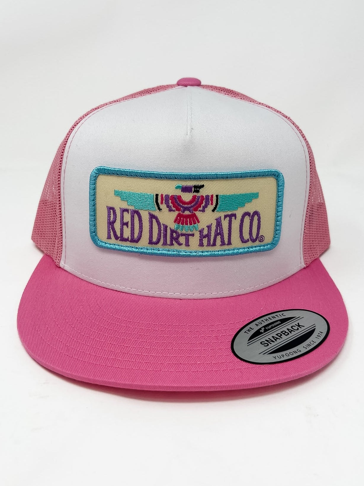 Pink and white trucker hat with 'Red Dirt Hat Co.' logo on a white background