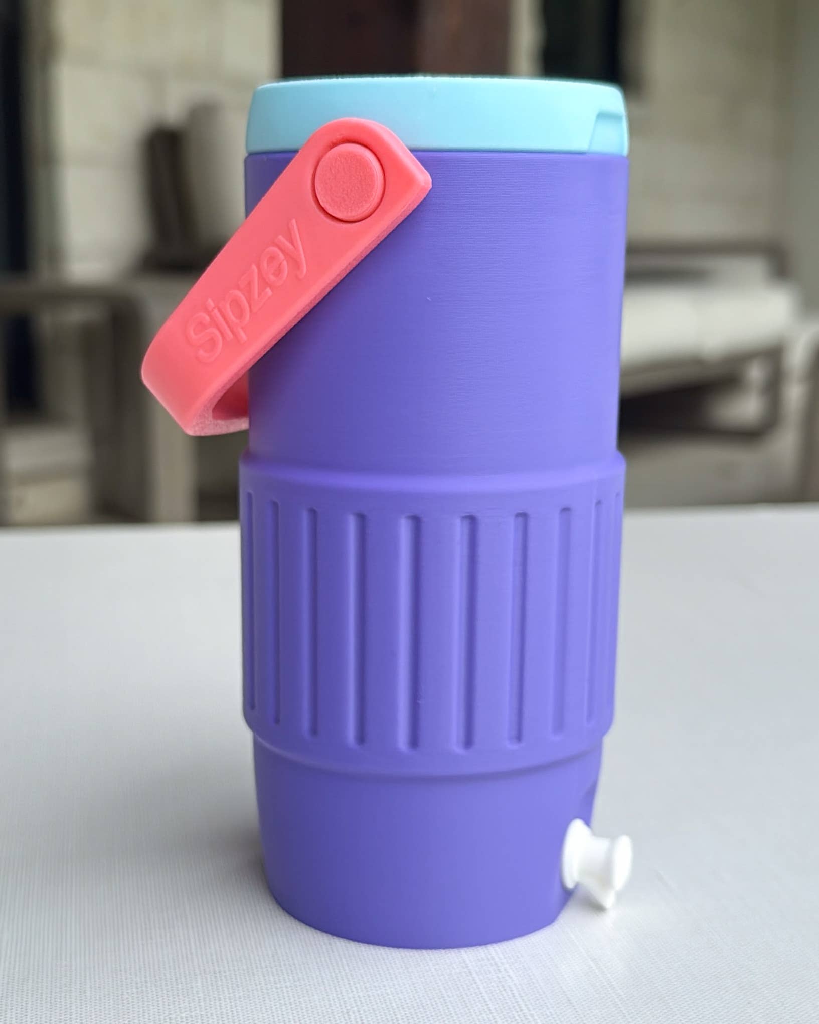 Purple water bottle with a pink cap on a white surface