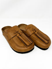 Pair of brown loafers with tassels on a white background