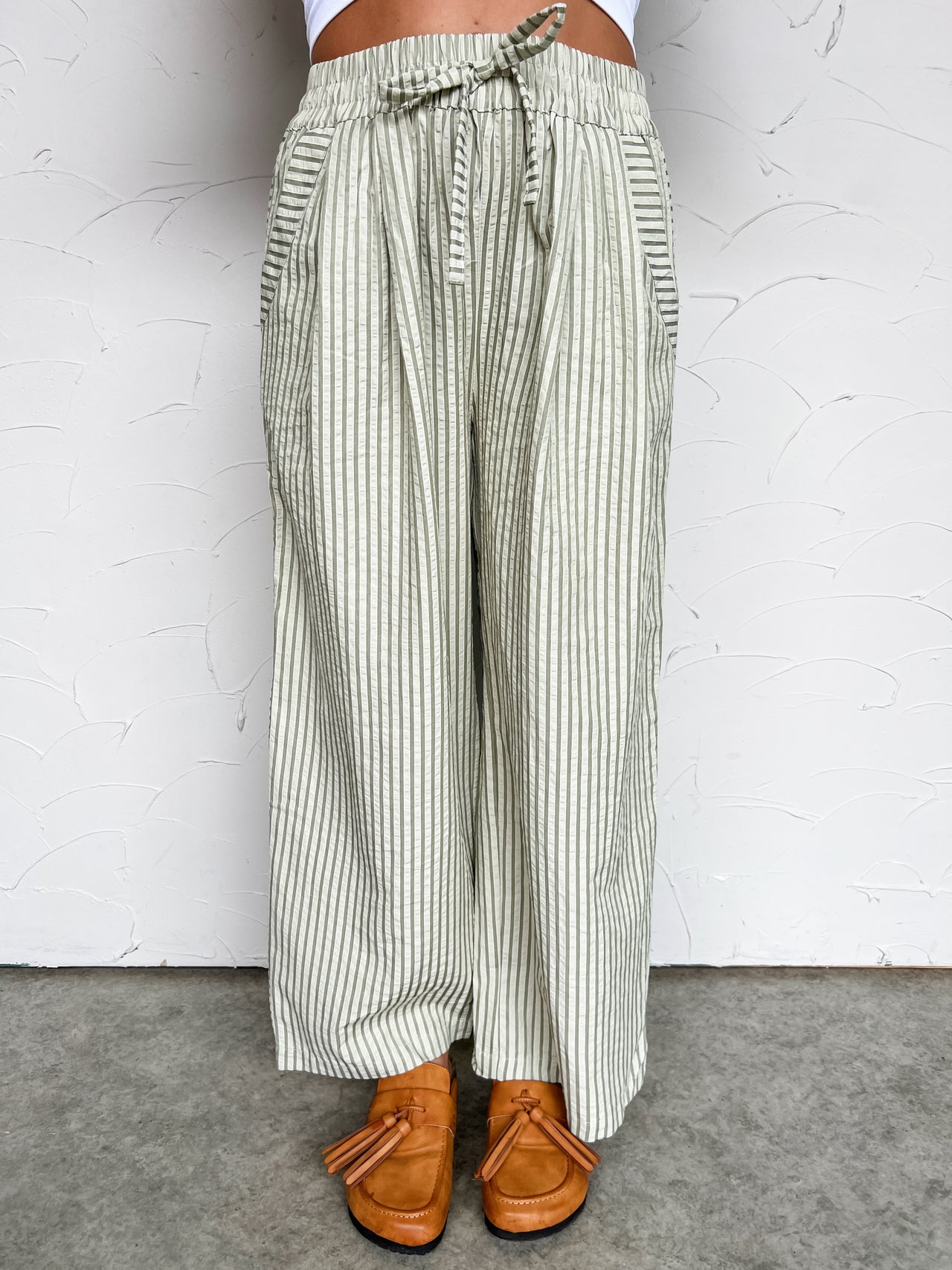 Striped wide-leg pants worn by a person on a white background