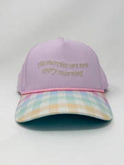 Purple cap with plaid brim and embroidered text on a white background
