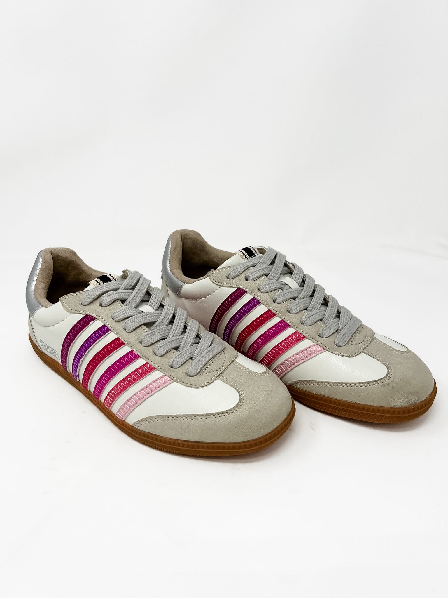 Pair of gray sneakers with different shades of pink stripes on a white background