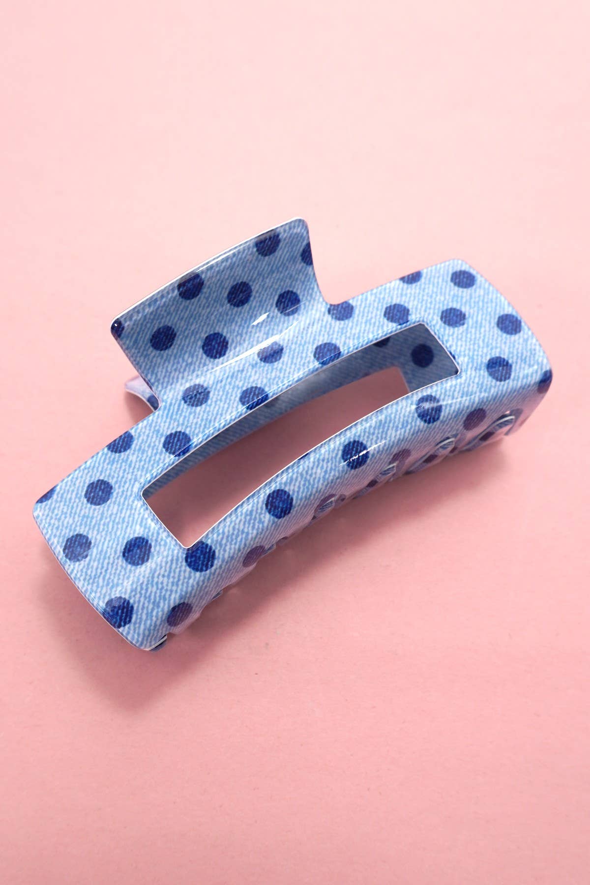 Blue polka dot hair clip on a pink background