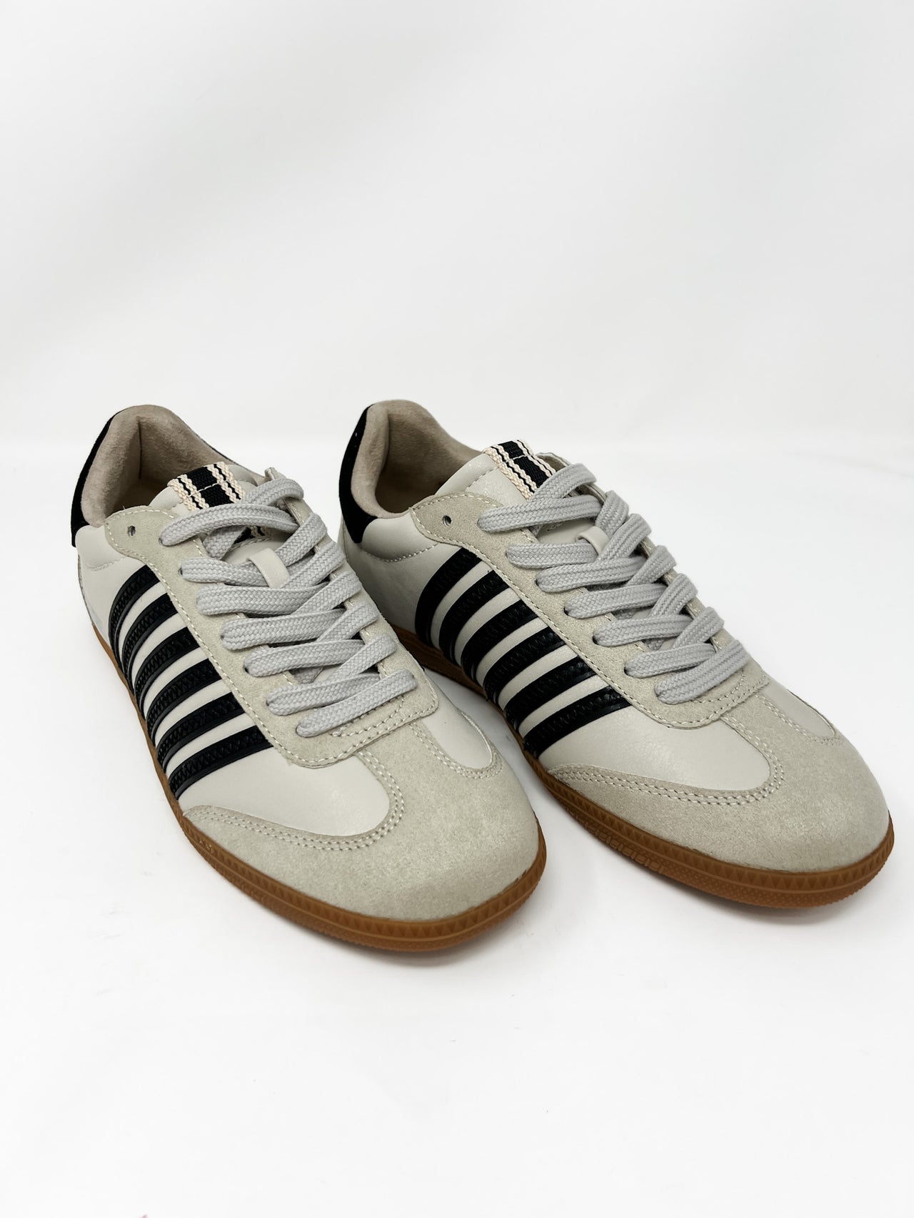 Pair of light gray & white sneakers with black stripes on a white background