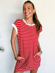Woman wearing a red and white striped dress against a white background