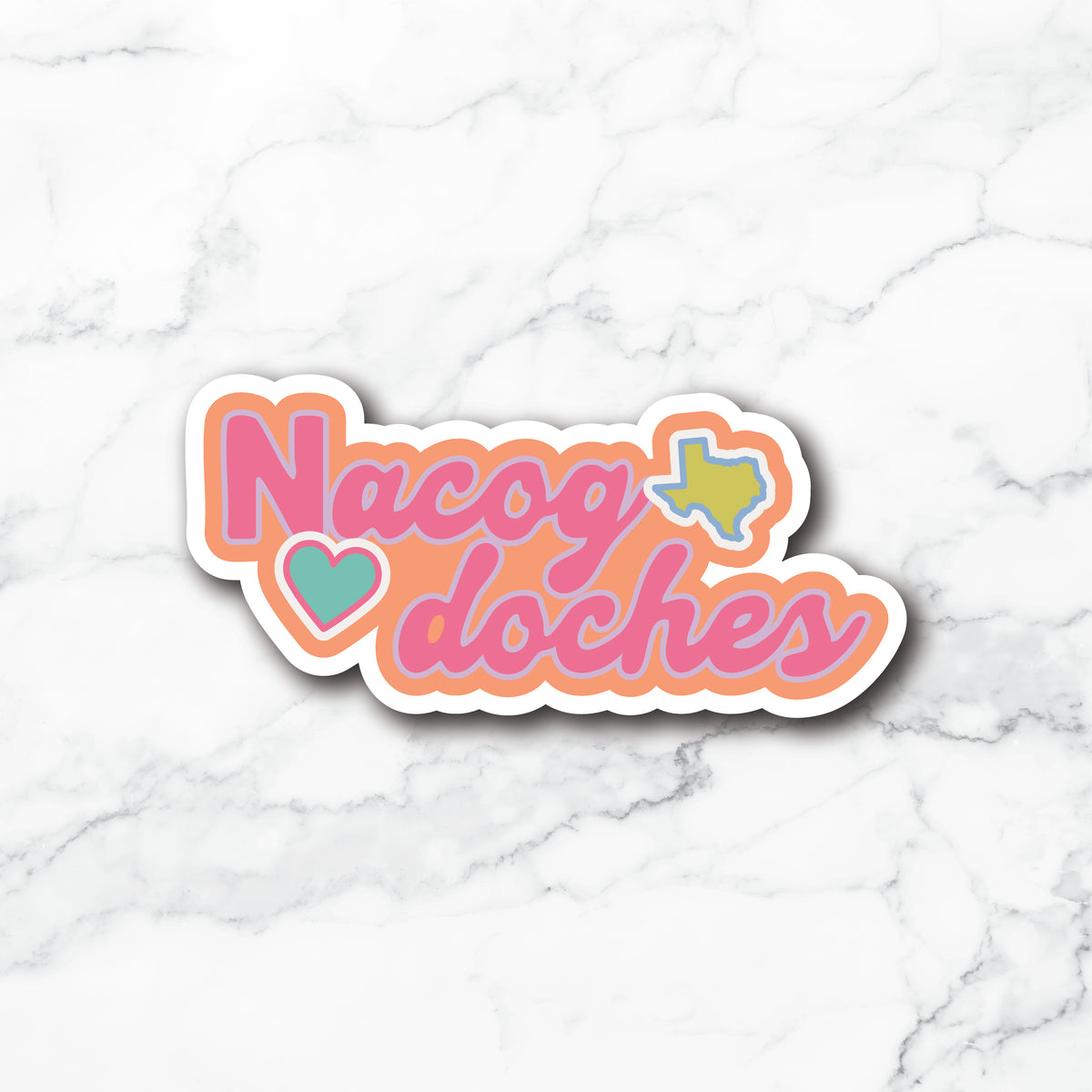 A die-cut sticker with the text 'Nacog doches' in pink script, outlined in peach and white, with a teal heart and a teal Texas state silhouette, shown on a white marble background.