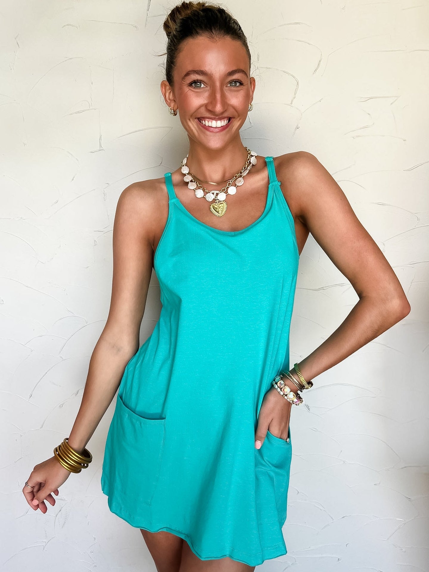 Woman wearing a turquoise dress with a white background