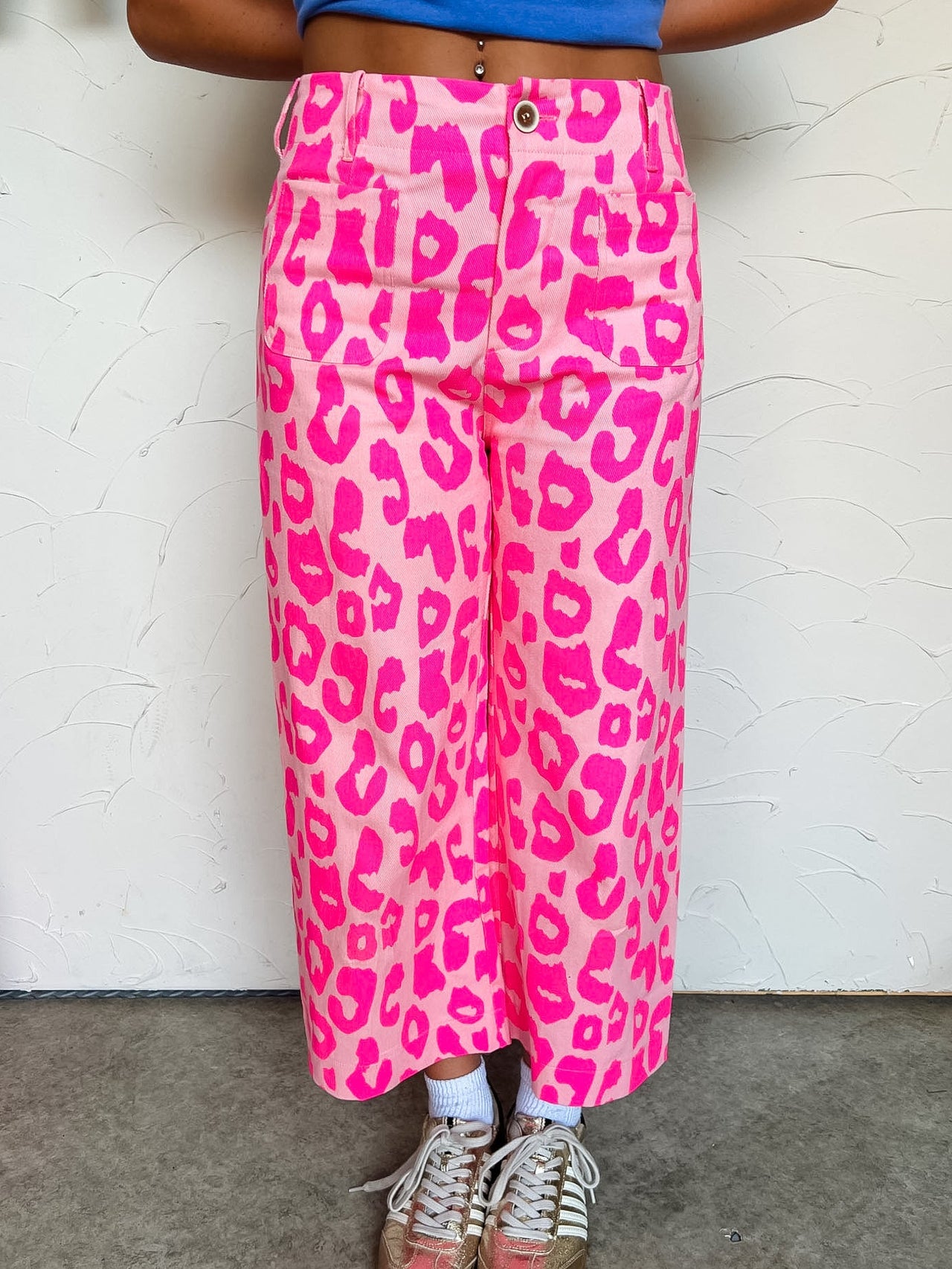 Person wearing pink leopard print pants with a white background