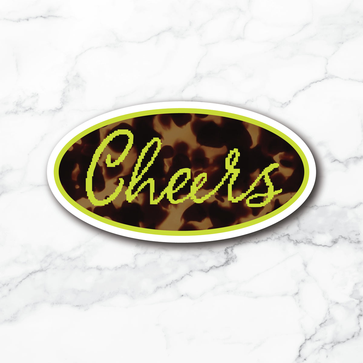 An oval die-cut sticker with the word 'Cheers' in bright neon yellow-green script over a brown and black leopard print background, shown on a white marble surface.