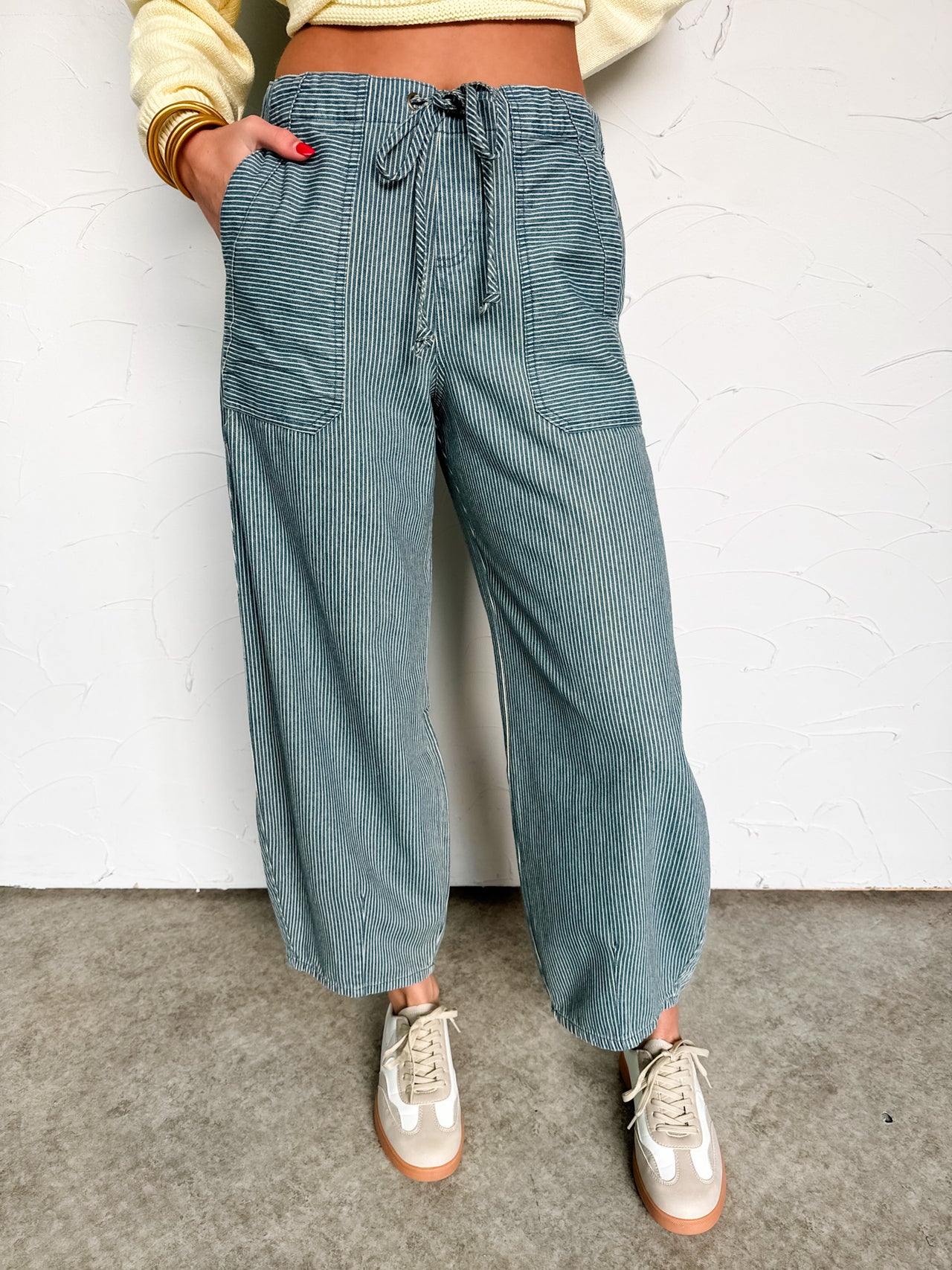 Person wearing teal corduroy pants with a white background
