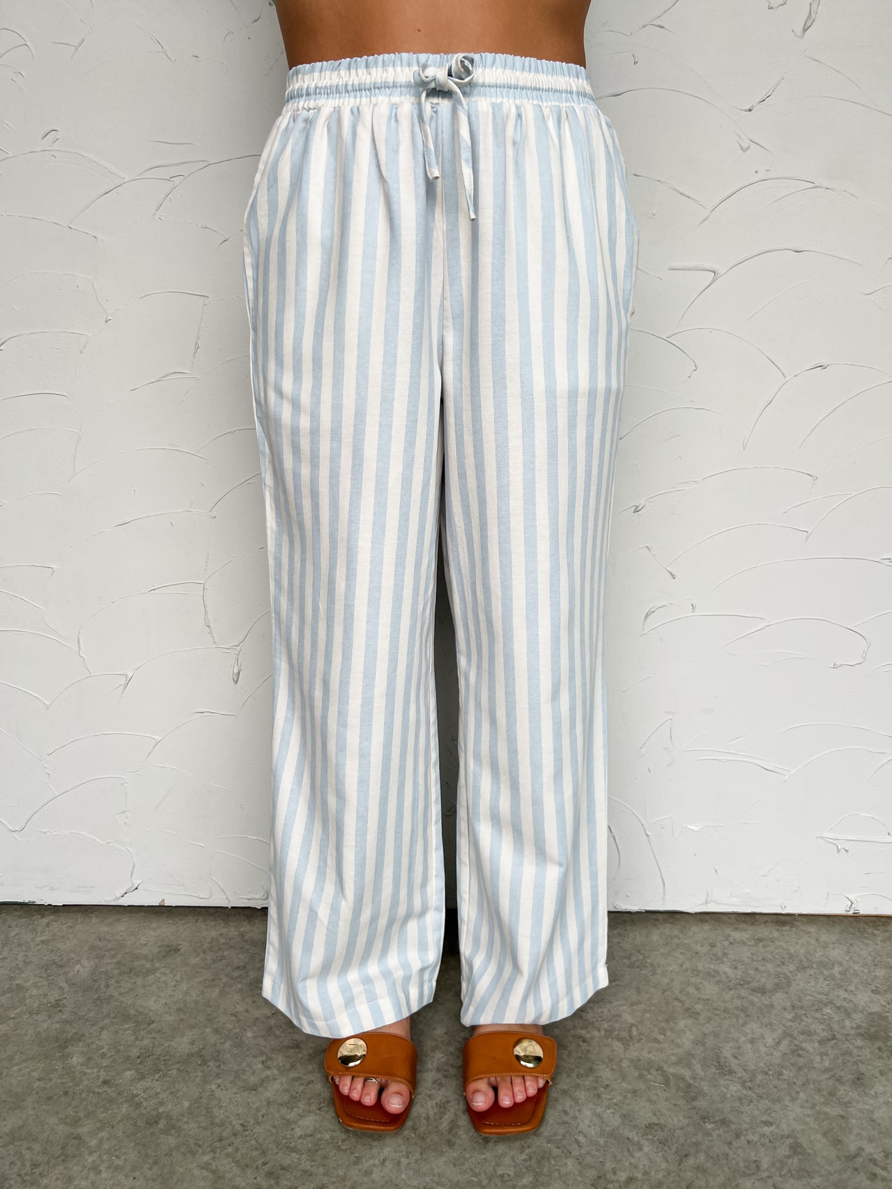 Striped pants worn by a person on a plain background