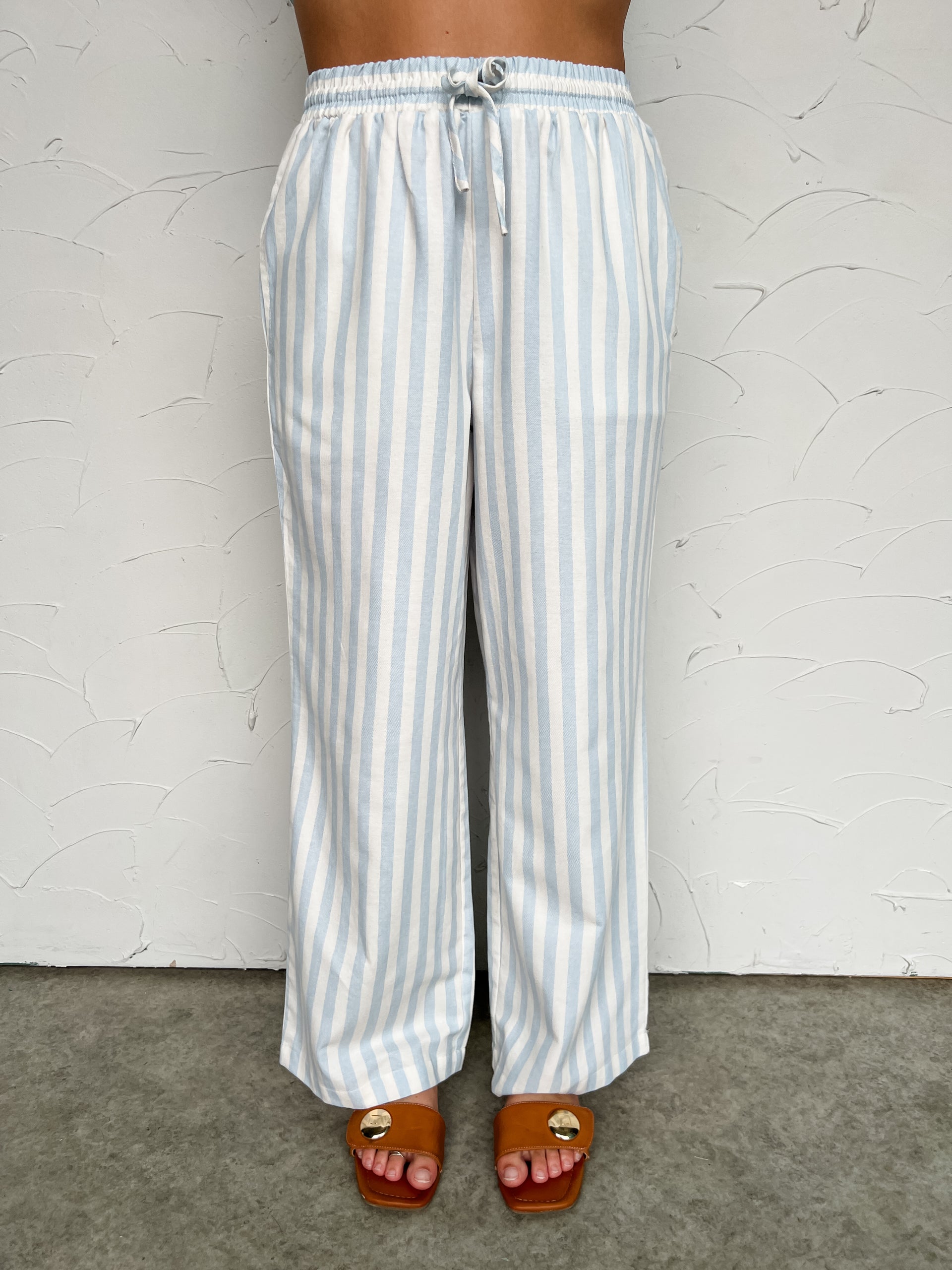Striped pants worn by a person on a plain background