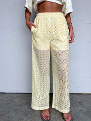 Person wearing light yellow lace pants against a plain background