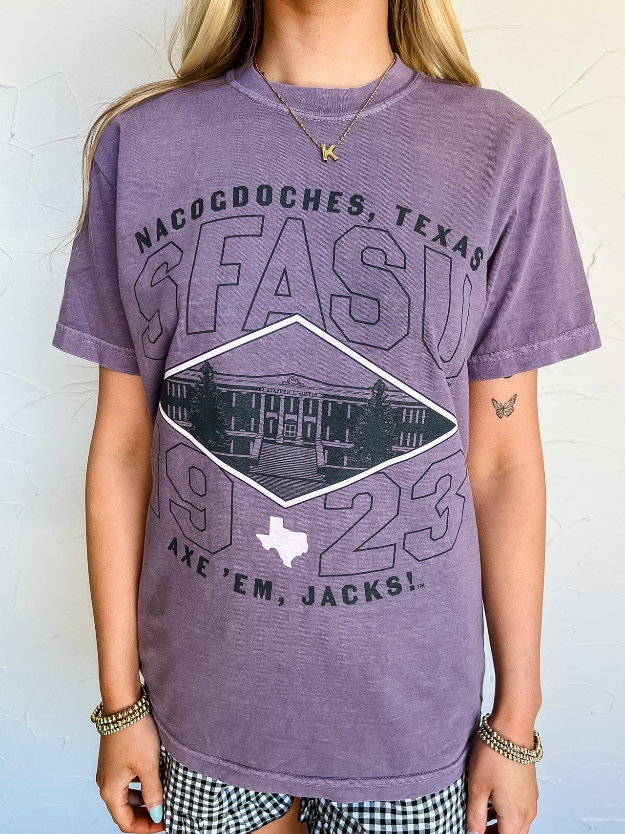 Person wearing a purple t-shirt with 'Nacogdoches, Texas SFASU 1923 Axe 'Em, Jacks!' design.