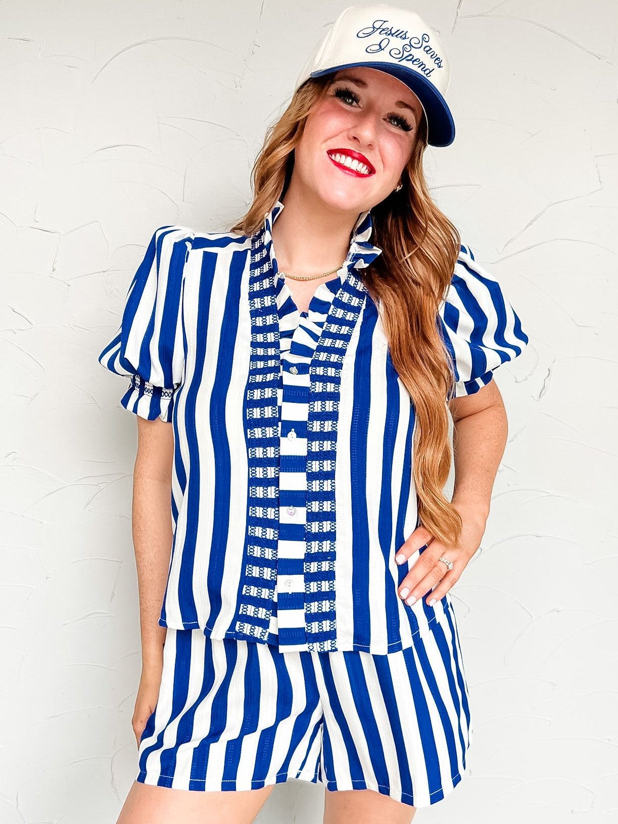 Woman wearing a blue and white striped set with a matching cap against a white background