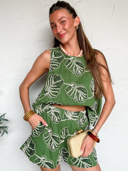 Woman wearing a green and white leaf-patterned set outfit against a white background