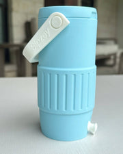 Blue collapsible water bottle with a white cap on a light surface.