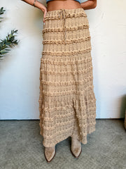 Beige textured skirt worn by a person on a neutral background