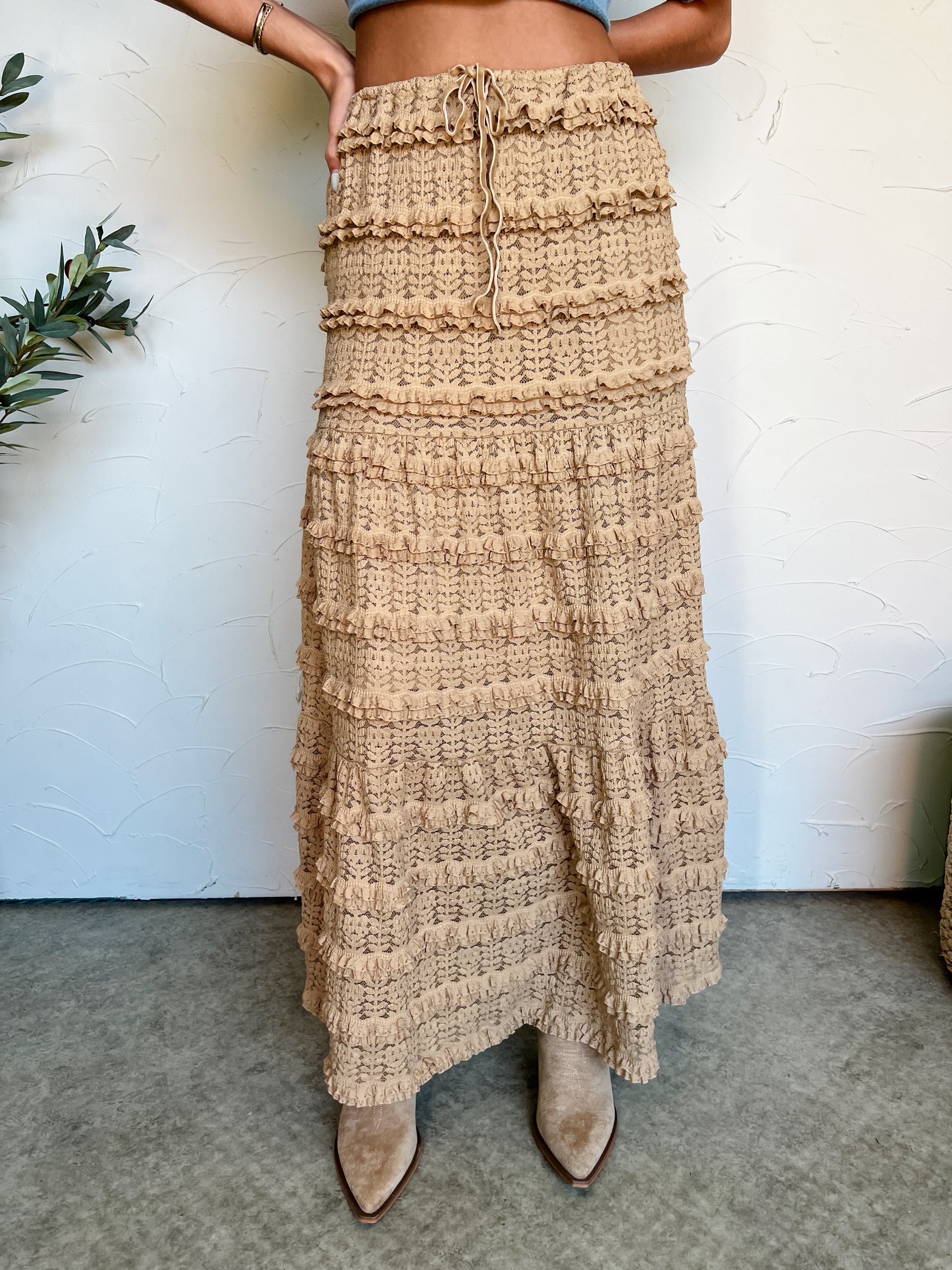 Beige textured skirt worn by a person on a neutral background