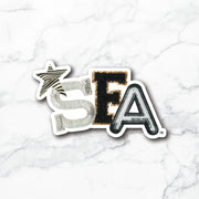 A die-cut sticker featuring the letters 'SEA' in a textured, metallic font on a white marble background. The 'S' is silver with a zebra-stripe star above it, the 'E' is black with gold glitter trim, and the 'A' is black with silver glitter trim.
